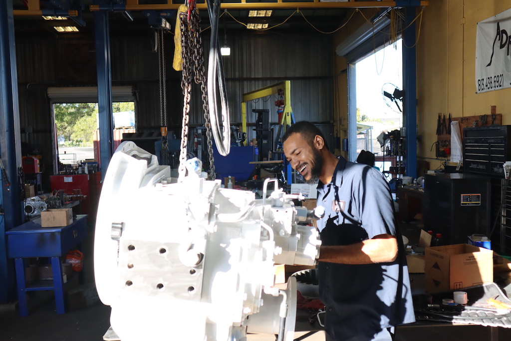 Mechanic smiling inspecting an engine