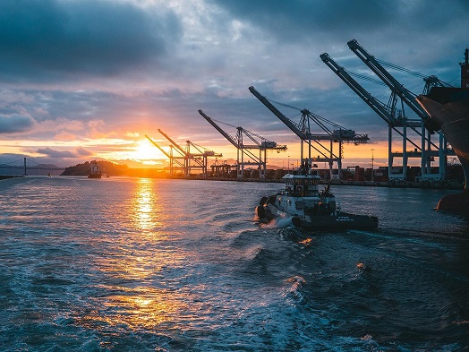 Background image featuring a tugboat sailing into the sunset